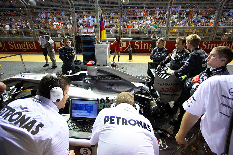 Mercedes GP mechanics prepare Michael Schumacher's Mercedes car on the grid before the race