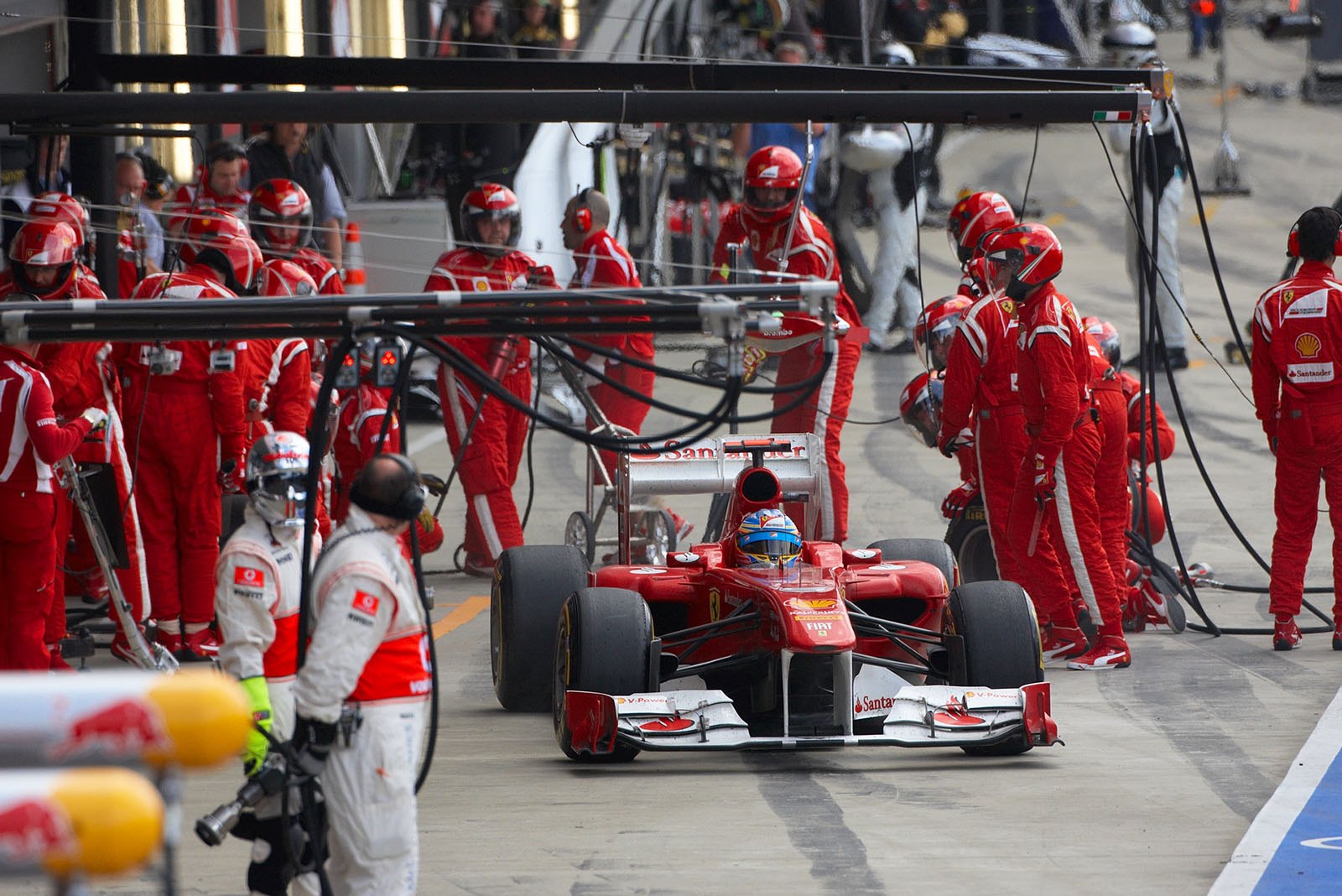 Alonso rushes away from Ferrari pits in order to overtake Vettel who is still in the pitting