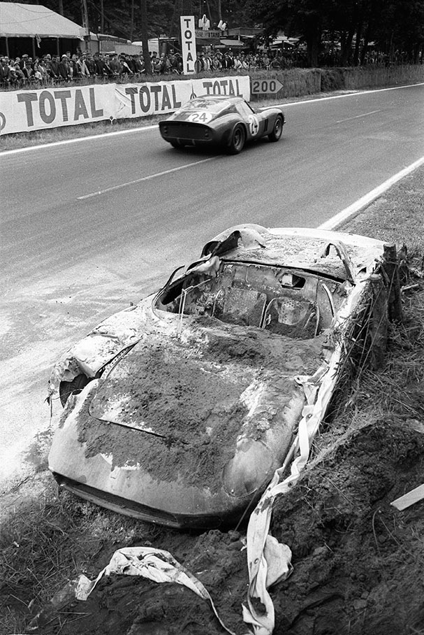 The incinerated Ferrari 250P #0812 of John Surtees (GB) and Willy Mairesse (B) is being passed by the Ferrari 250 GTO #4293GT of "Jean Beurlys" (B) and Gerard Langlois von Ophem (B)