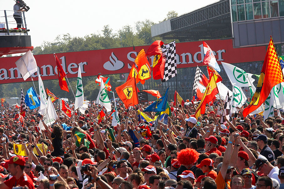 Fans cheer and wave their flags on the overcrowded track during the podium ceremony