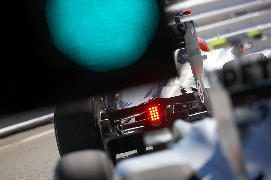 Michael Schumacher, Mercedes GP, passes the green signals at pit lane exit in front of team mate Rosberg