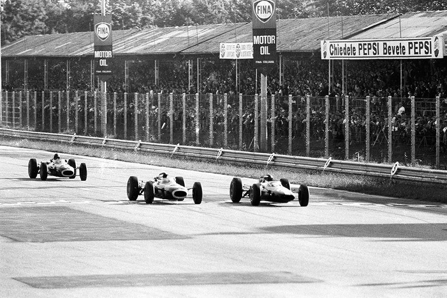 Race winner Jackie Stewart on a BRM P261, his senior team mate Graham Hill and Jim Clark in a Lotus-Climax 33 (car no. 24, started from pole position but retires with fuel pump problems after 63 of 76 laps) fight wheel to wheel for the lead during the Italian GP at Monza in 1965.