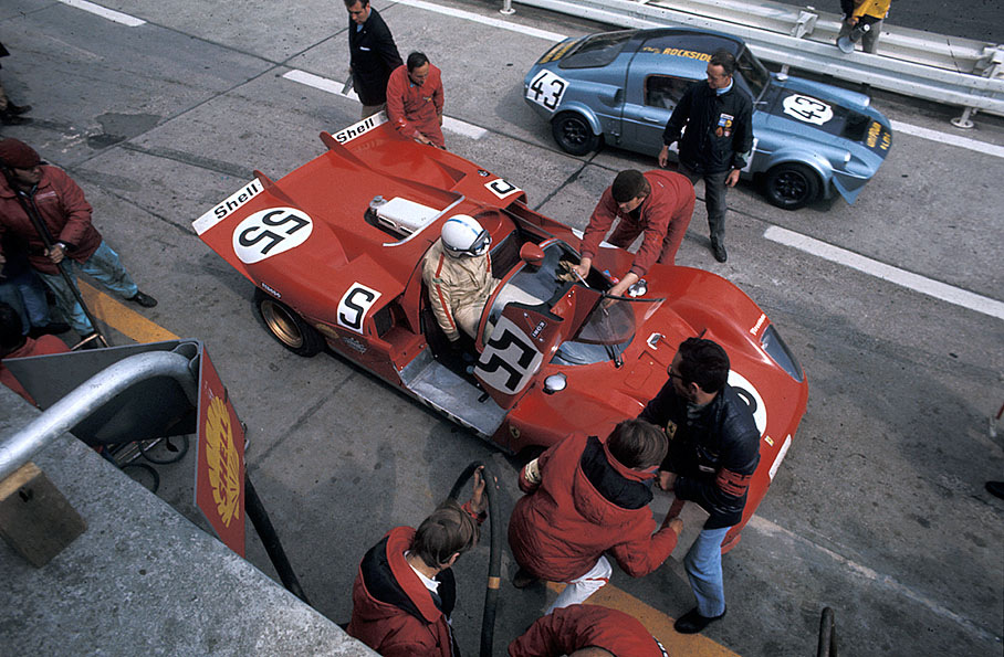 John Surtees (GB) takes a seat in the Ferrari 512 S Spyder #1042 whilst the Unipower GT BMC driven by Stanley Robinson (GB) and John Blanckley (GB) passes by in pitlane