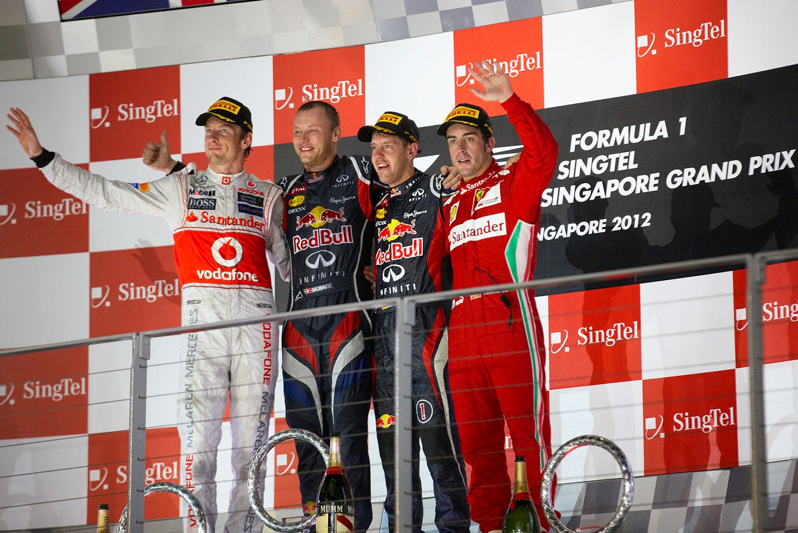 Race winner Sebastian Vettel of Red Bull Racing celebrates on the podium with his mechanic Ole Schack, second placed Jenson Button of McLaren and third placed Fernando Alonso of Ferrari