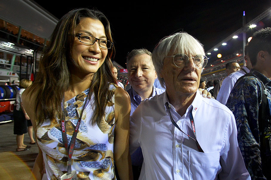 Bernie Ecclestone walks on the grid with Jean Todt's wife Michelle Yeoh