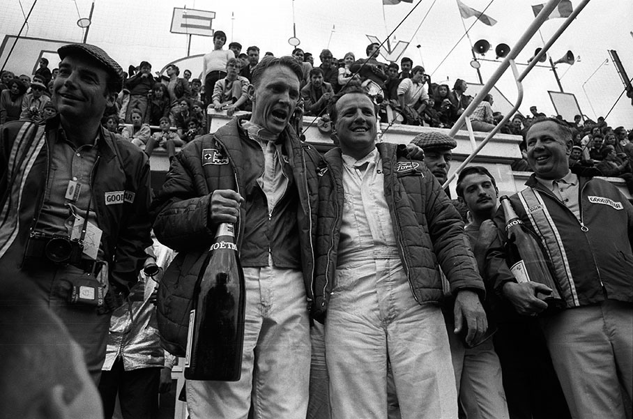 Winning team (category P+5.0) Dan Gurney (USA) and A. J. Foyt (USA) celebrate with champagne on podium, legendary photographer and journalist Bernard Cahier left hand