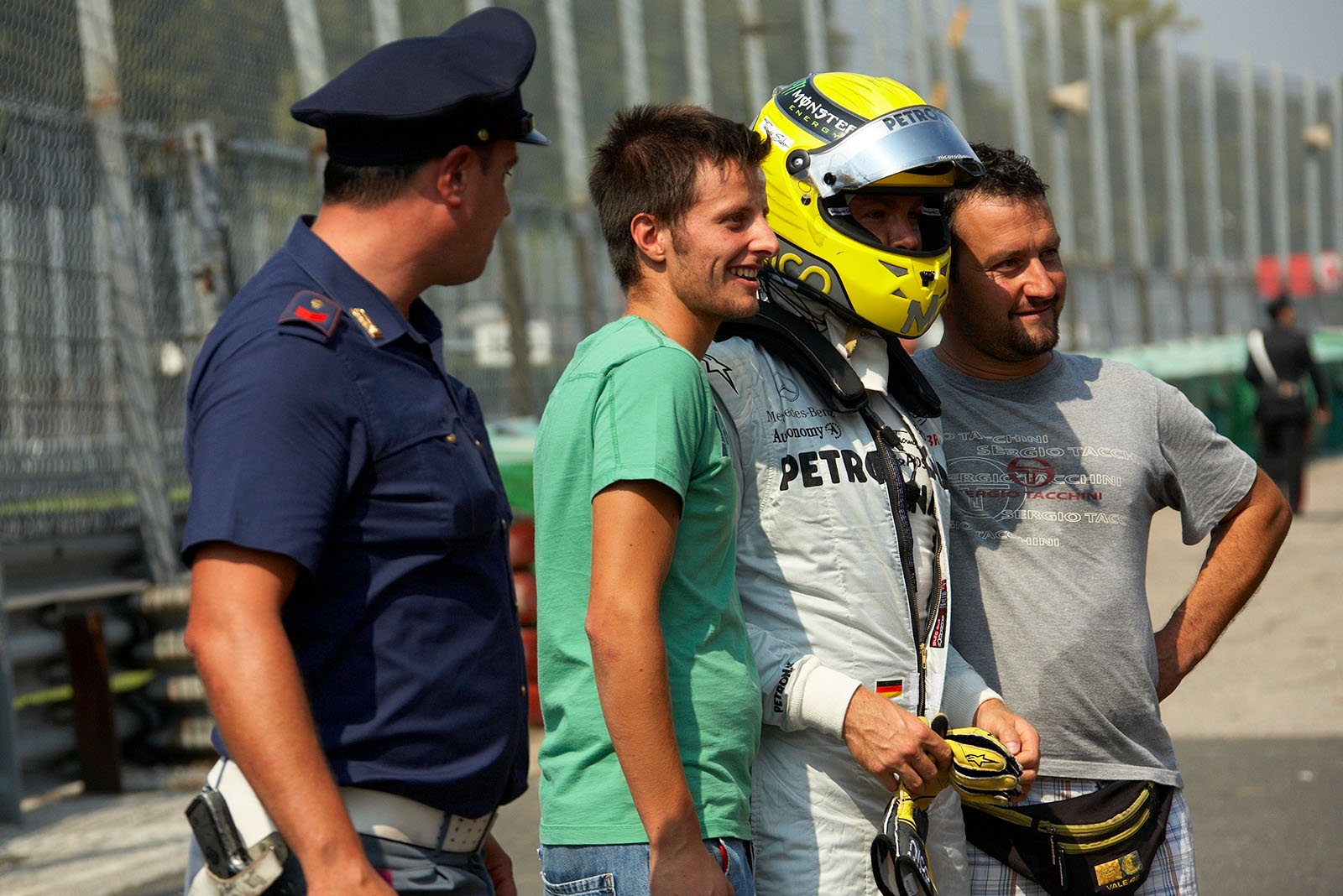 After the start accident the race has ended for Nico Rosberg, but he poses politely with souvenir chasing locals