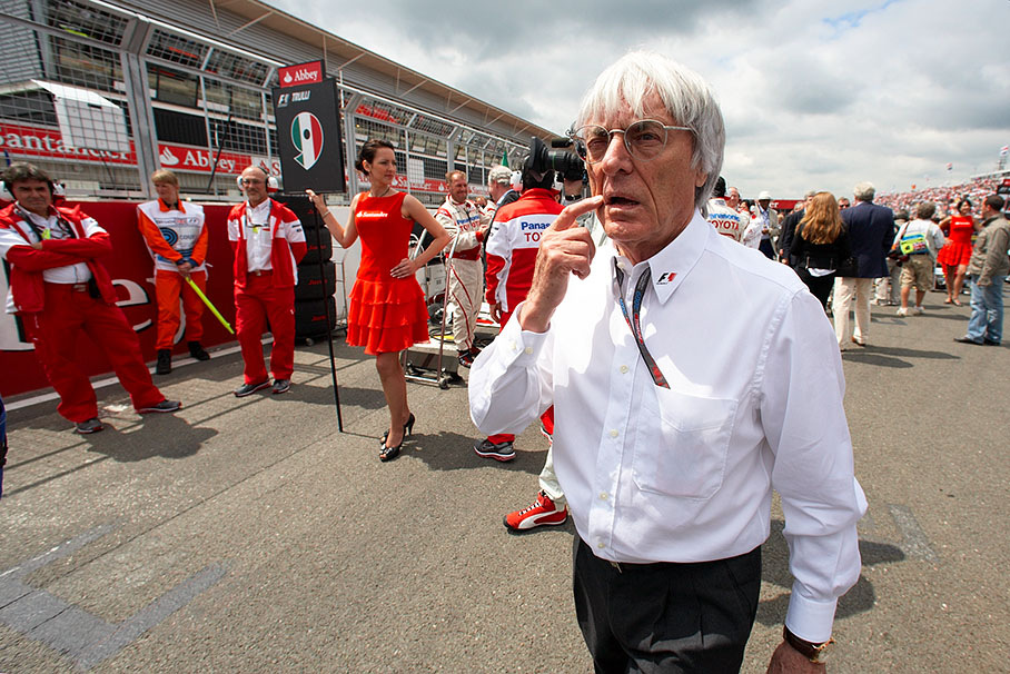 Bernie Ecclestones walks on the grid besides Trulli's grid position