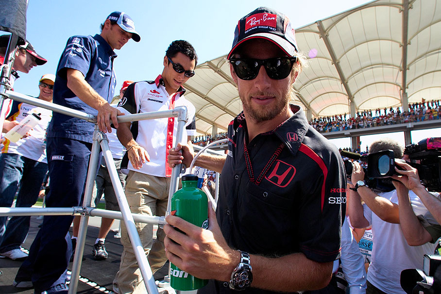 Jenson Button descends from drivers parade truck in front of Sato and Wurz