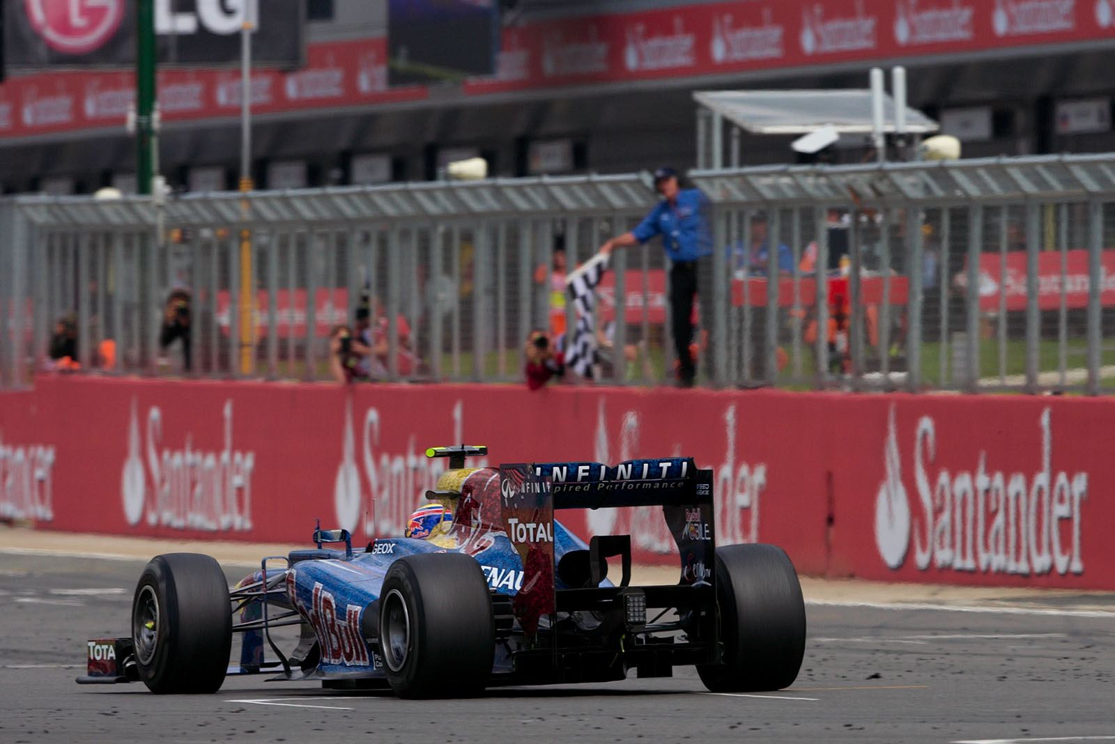 Race winner Mark Webber of Red Bull Racing takes the chequered flag
