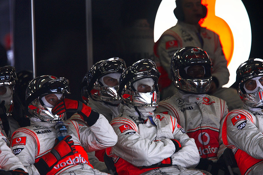 McLaren mechanics watch the race in their pits