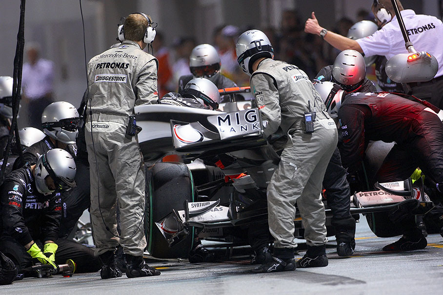 Michael Schumacher stops at Mercedes GP pits with a damaged front wing after a collision with Heidfeld