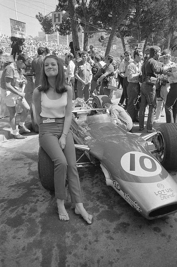 Jackie Oliver's wife Lynn, sitting on a wheel of his car here in Monaco, occasionally jobbed as advertising girl for Lotus' main sponsor Gold Leaf