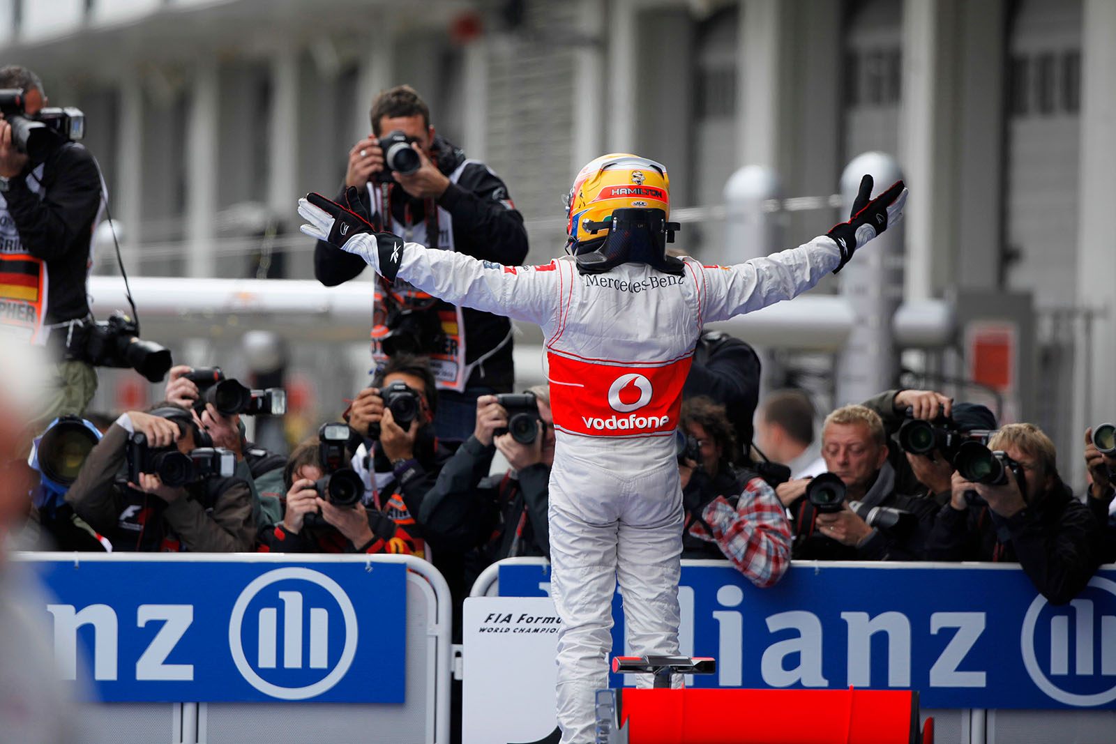 Race winner Lewis Hamilton of McLaren cheers in front of the photographers who surround parc ferme after the race