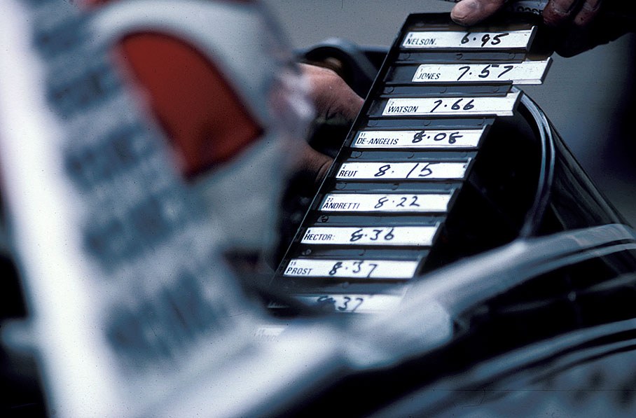 Nelson Piquet watches an information panel with his opponent's lap times