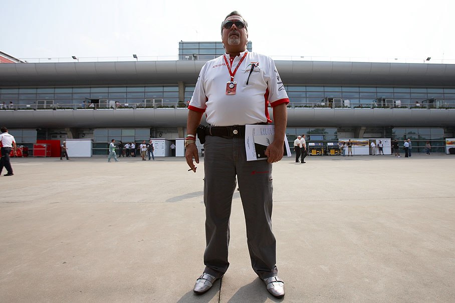 Force India team principal Vijay Mallya stands in the paddock like a statue