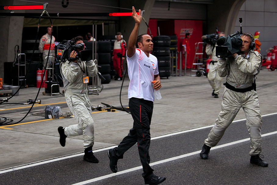 After retiring and changing clothes Hamilton crosses pitlane and waves greetings to his fans