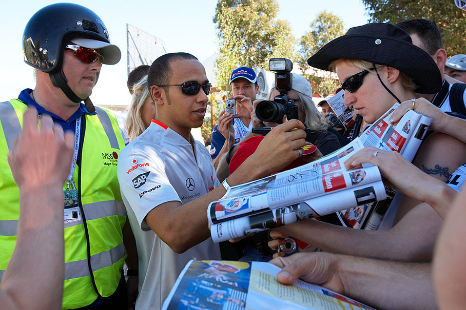 McLaren's Lewis Hamilton enjoys a bath among the crowd of fans, of course flanked by an alert security officer