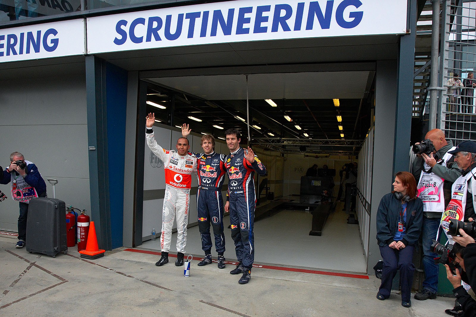 The fastest three qualifiers wave at the world's media: on the left hand second qualified McLaren's Lewis Hamilton, Red Bull driver Sebastian Vettel as polesetter in the middle and his team mate Mark Webber as third on the grid