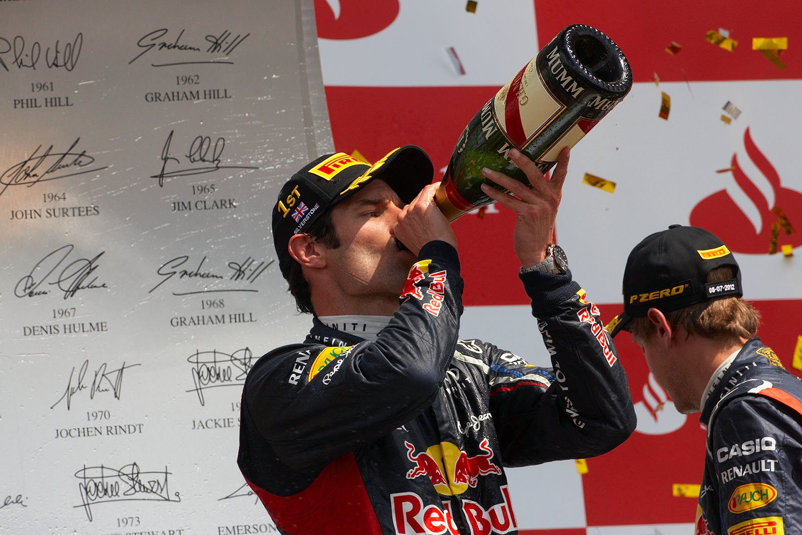 Race winner Mark Webber of Red Bull Racing takes a big pull from the bottle of champagne on the podium