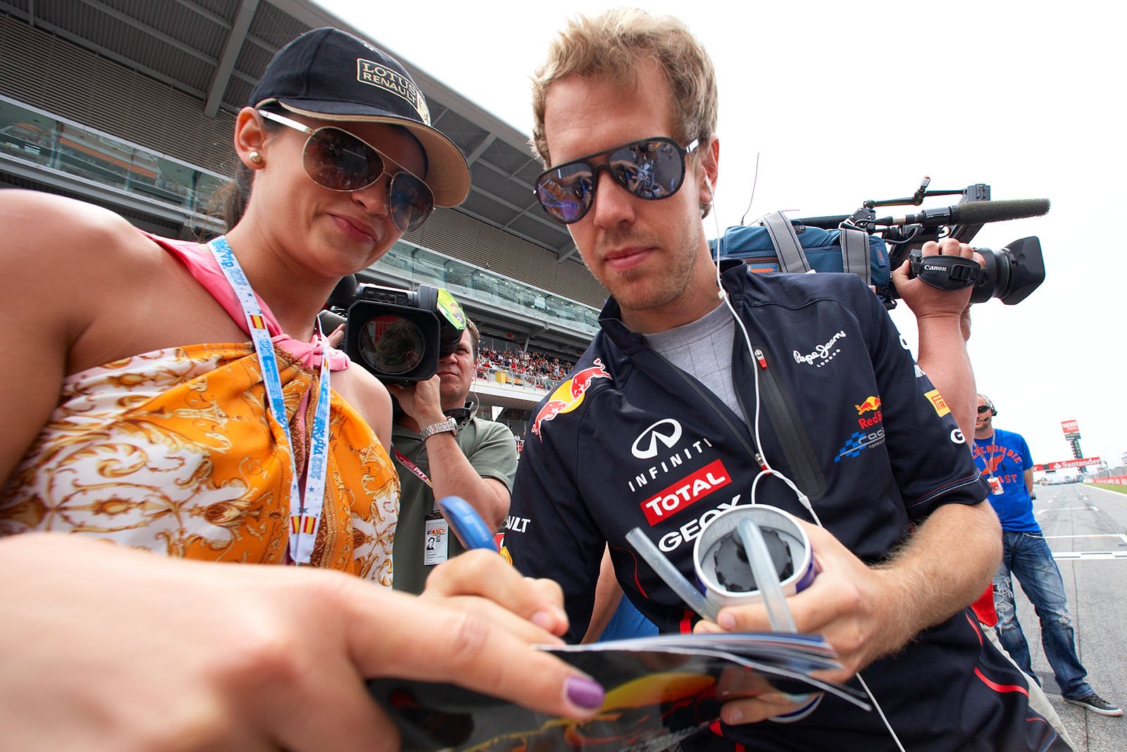 Red Bull's Sebastian Vettel gives an autograph