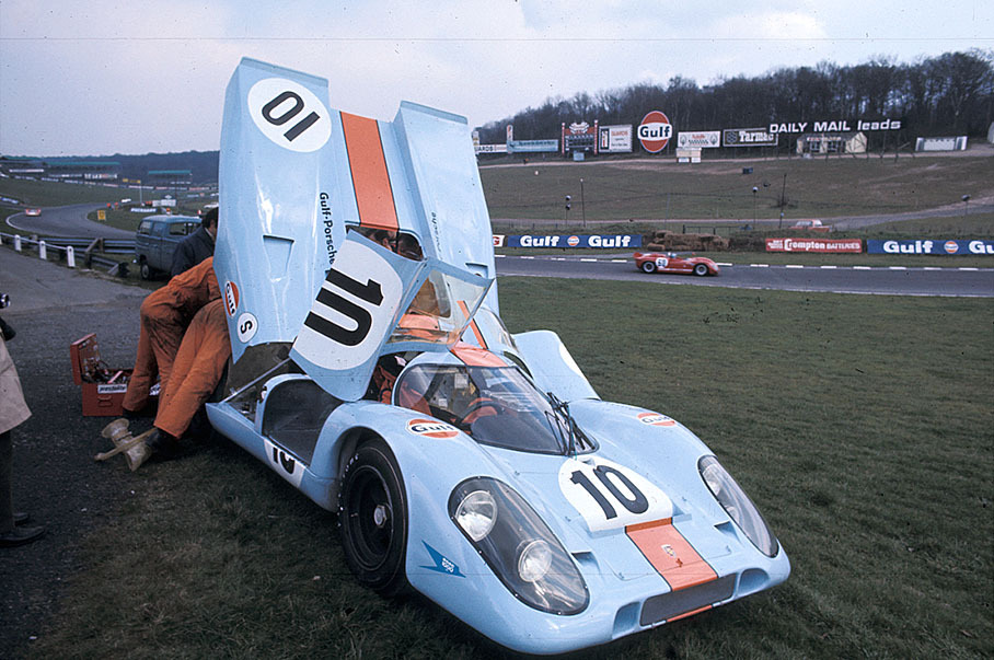 The Porsche 917K 016 of Pedro Rodriguez (MEX) and Leo Kinnunen (SF) is being repaired besdides the track whilst a red car passes