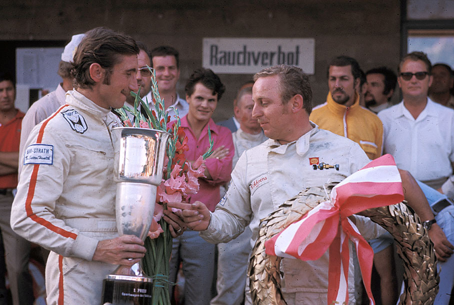 Winning driver team Jo Siffert and Kurt Ahrens admire their trophies, the Porsche 917 #009 was entered by Freiherr von Wendt, note Bonnier in the background