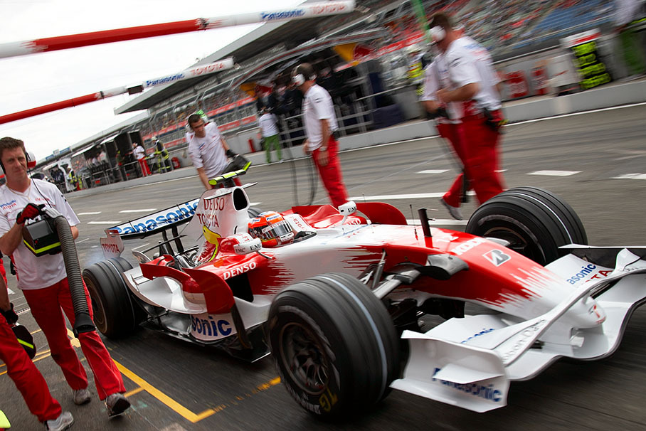 Timo Glock practices a pit stop with the Toyota pit crew