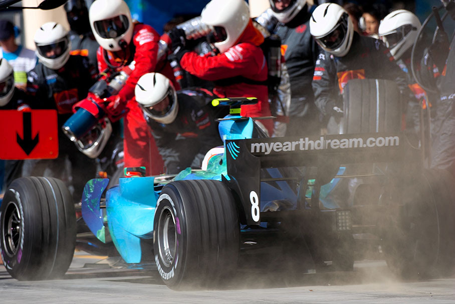 Rubens Barrichello pits in through a cloud of dust