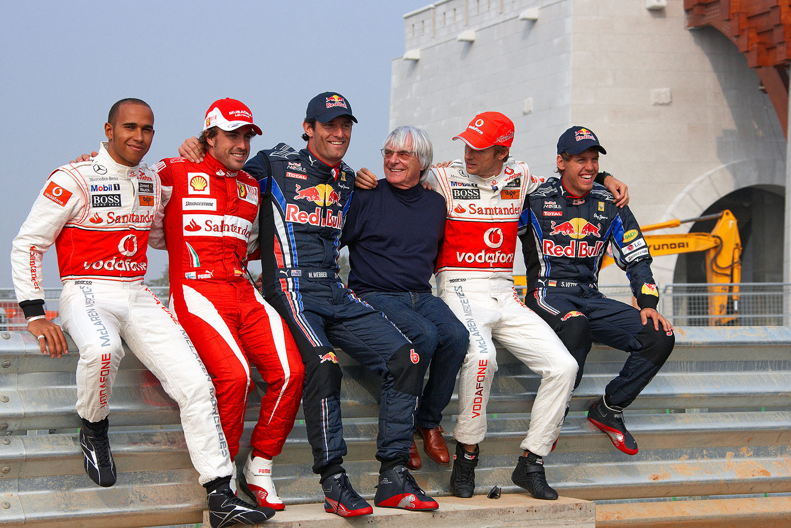 Formula One god father Bernie Ecclestone sits on a rail for a group photo with the top five drivers Lewis Hamilton, Fernando Alonso, Mark Webber, Jenson Button and Sebastian Vettel