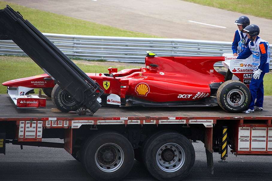 Alonso's damaged car is being removed after practice session