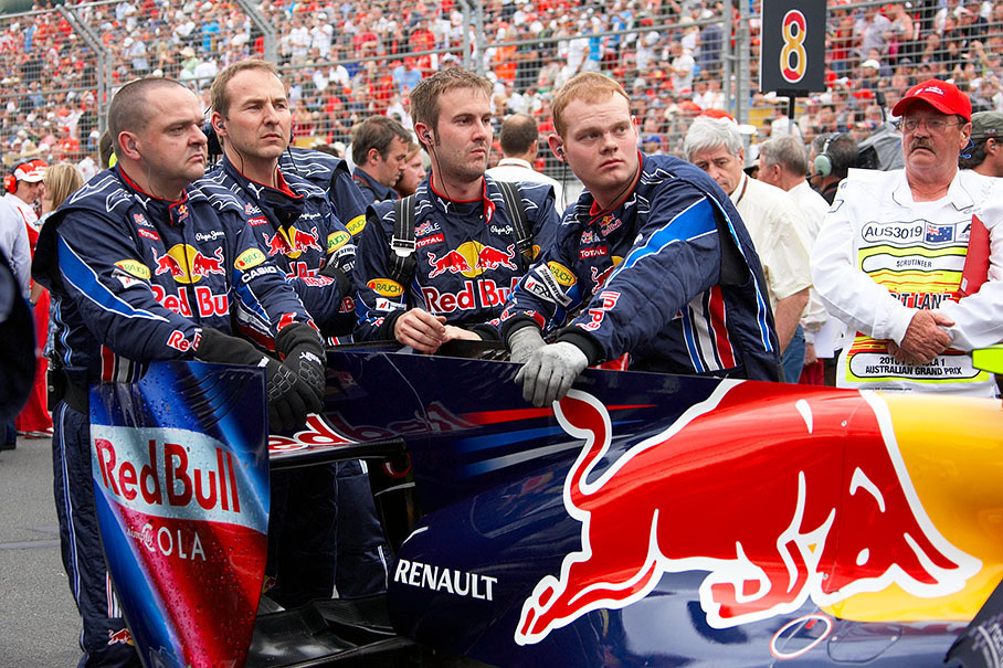 Red Bull mechanics stand behind Webber's car to hide the diffusor