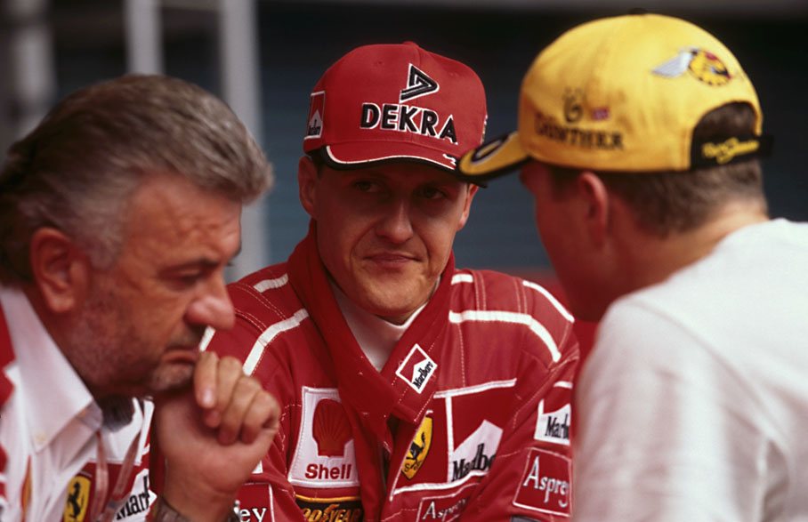 Michael Schumacher discusses with his brother Ralf and manager Willi Weber