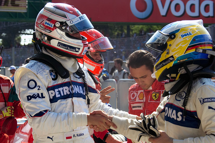 Robert Kubica receiving congratulations from his teammate Nick Heidfeld for achieving grid position six and three for their BMW Sauber cars