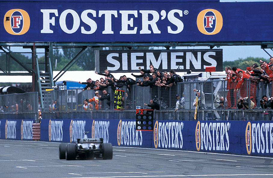 Kimi Raikkonen passes the cheering McLaren Mercedes team and becomes second at the British Grand Prix 2004