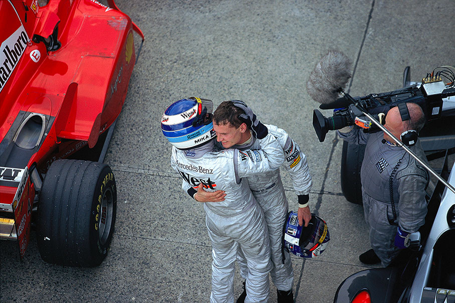 Race winner and new world champion Mika Hakkinen hugs his McLaren team-mate and third placed David Coulthard in parc ferme