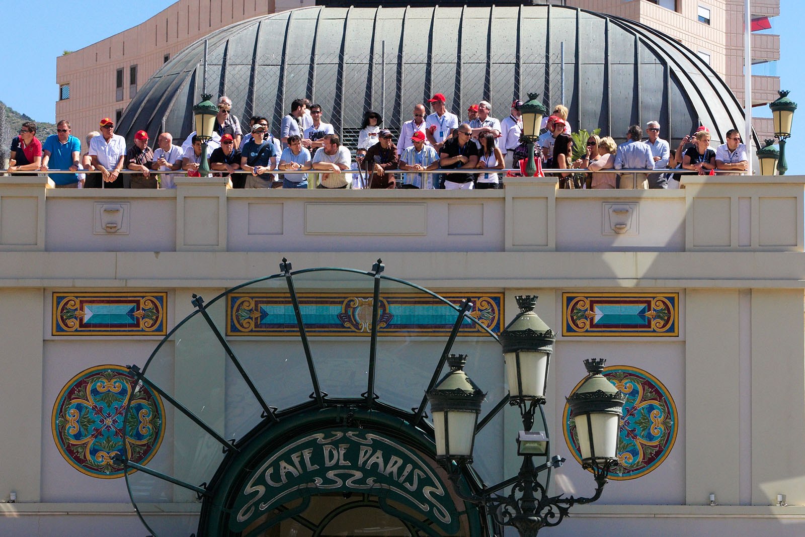 Fans gather above Cafe de Paris on a terrace.