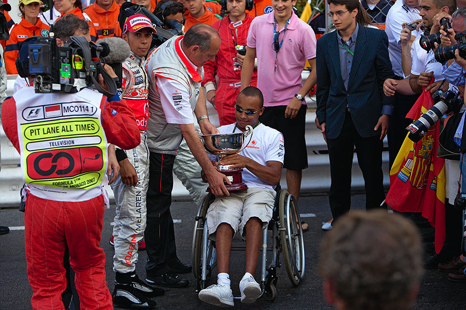 McLaren team principal Ron Dennis hands over the winning constructor's trophy to Lewis Hamilton's brother Nicolas