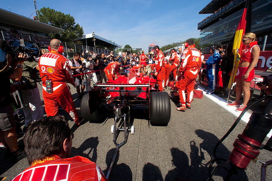 Michael Schumacher's car arriving at its grid position, already surrounded by waiting photographers