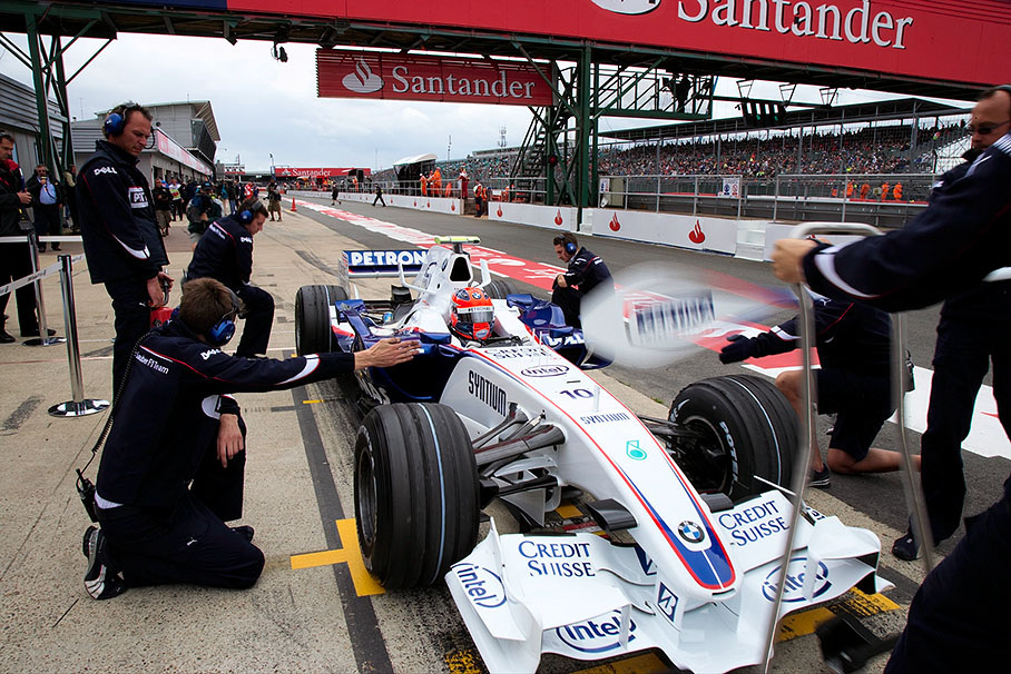 Robert Kubica practices a pit stop with his BMW Sauber mechanics