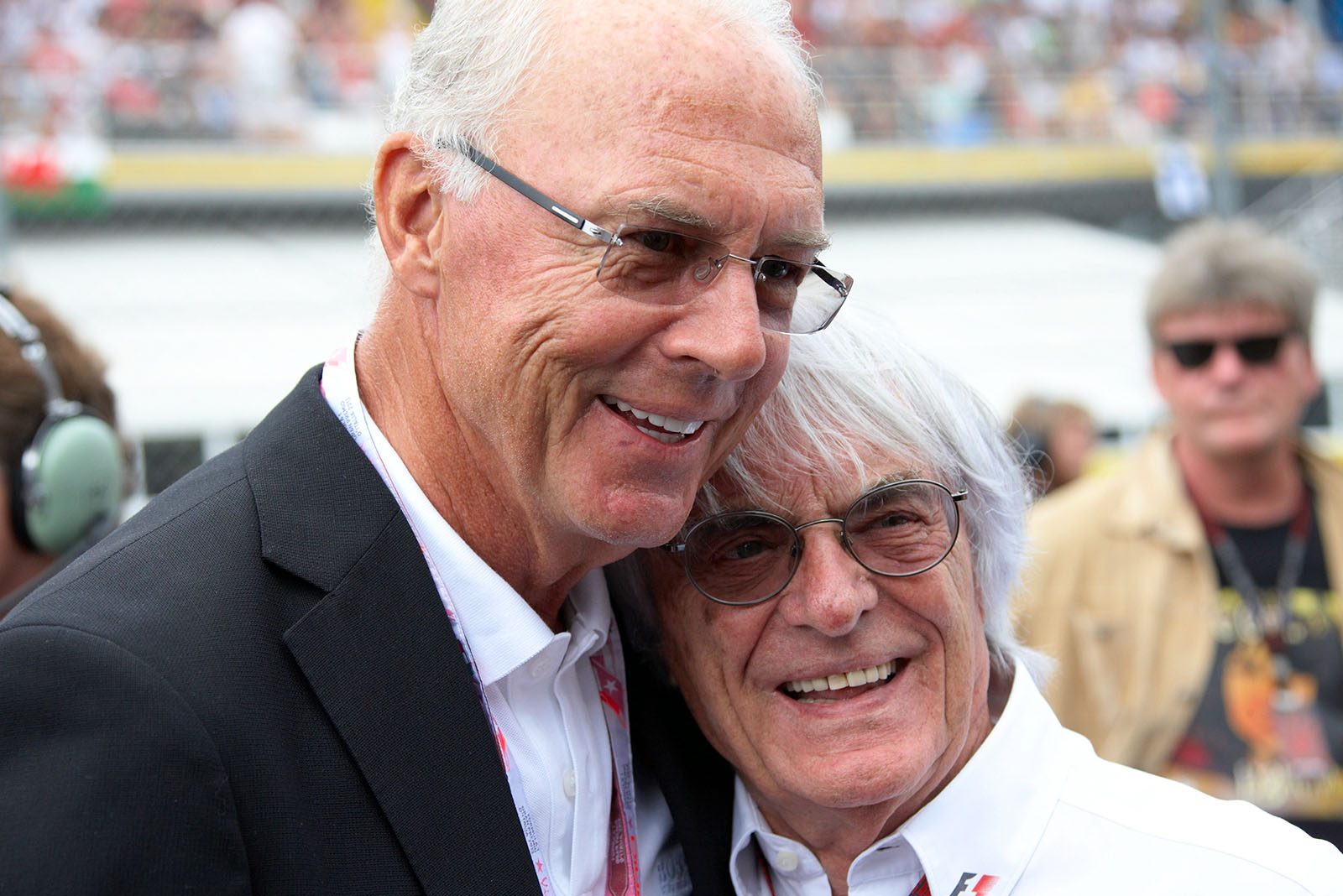 Bayern Muenchen chairman Franz Beckenbauer, hugs Formula One Group CEO Bernie Ecclestone before the race