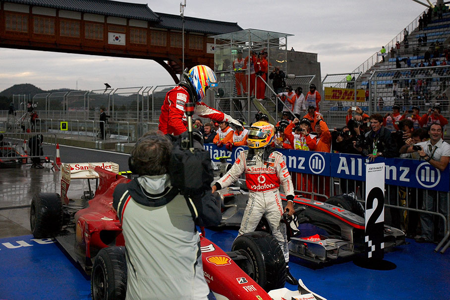 Ferrari's Fernando Alonso, winner of the first Korean GP, celebrates his first rain race win in parc ferme besides second placed Hamilton