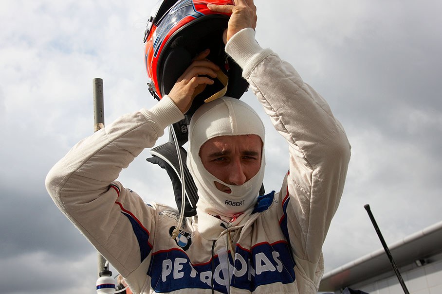 On grid shortly before the race, Robert Kubica puts his helmet on