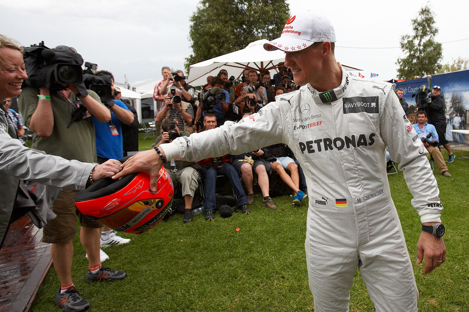 Michael Schumacher of Mercedes GP takes his helmet for drivers presentation from his manager Sabine Kehm