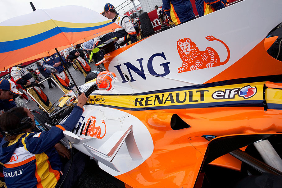 Nelsinho Piquet sits under an umbrella in his Renault car