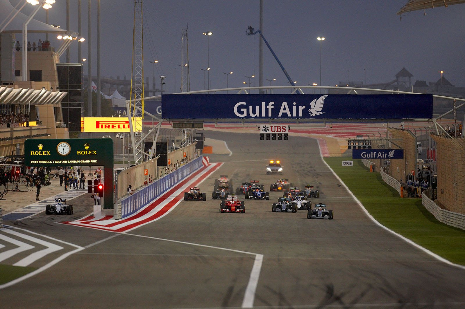 Start for the Bahrain Grand Prix, 2015, with Hamilton, Mercedes, and Vettel, Ferrari, in the lead. Massa, Williams, is about to join the race from the pitlane.