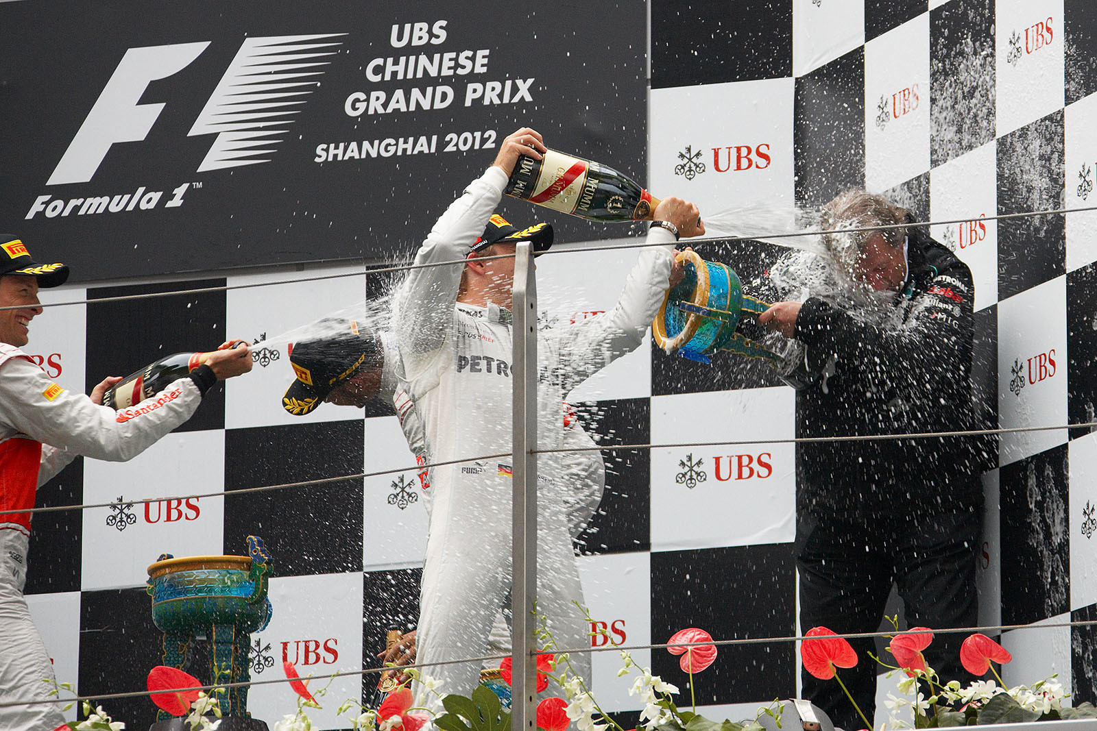 Mercedes motorsport director Norbert Haug catches a really strong sip of champagne