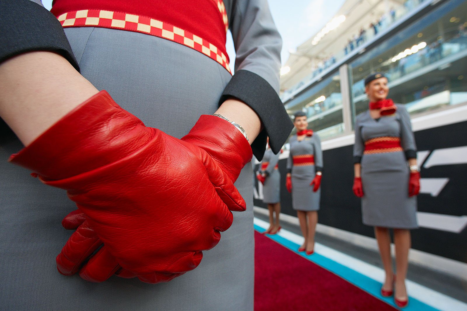 The red leather gloves of a grid girl