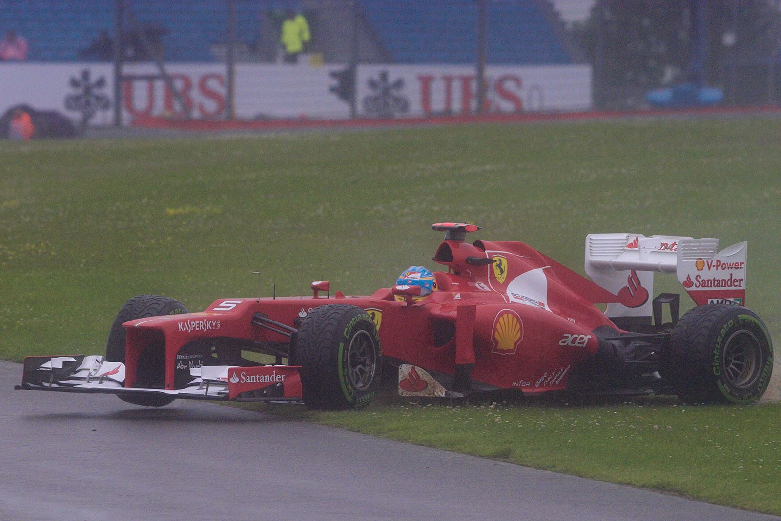 During a rainy practice session, Fernando Alonso slides off the track in his Ferrari