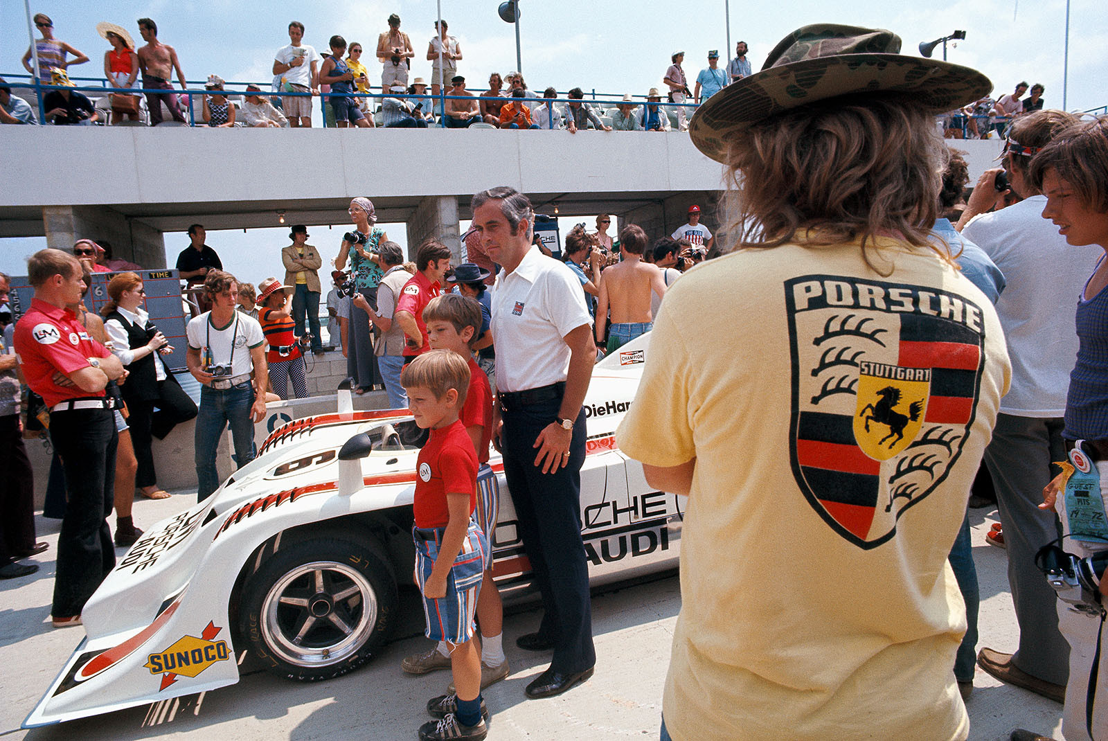 Can-Am Watkins Glen 1972: Roger Penske and two young race fans pose for a group photo besides the Porsche 917/10 TC